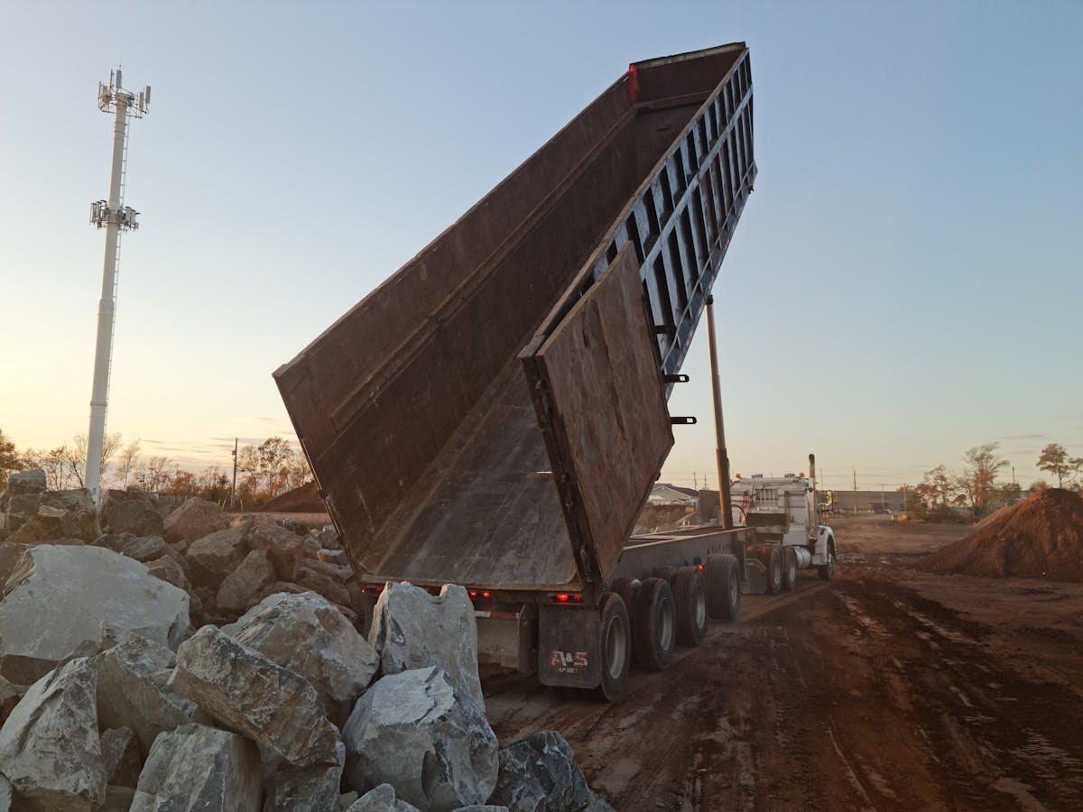 A dump truck emptying a load of mixed junk
